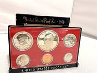 Close-up of the 1976 US Bicentennial Proof Set in plastic case showing front view of coins on red background insert and black case.