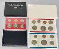 Photo showing the black case for the 1980 US Proof Set with coins mounted on a red insert, accompanied by two cellophane mint sets.