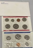 Envelope labelled 'U.S. MINT 1981 Uncirculated Coin' with two sealed coin sets in cellophane, one with red edging and one with blue edging representing Denver and Philadelphia mints respectively.