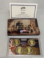 Front view of 2009 US Mint Presidential $1 Coin Proof Set with 4 coins in protective plastic case alongside certificate and coin specifications booklet.
