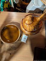Full view of the chicken-shaped reheating server and the matching ceramic rooster plate on a wooden surface.