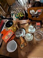 Wide shot showing all items in the lot including tea cups, Pyrex bowl, butterfly mirror, timer, and decorative items