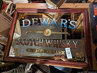 Full view of the framed Dewar's advertising mirror showing all text and decorative details.