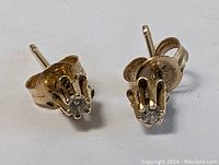 Front view of both gold diamond stud earrings displayed side by side.