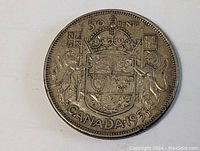 Obverse side of the 1953 Canadian silver half dollar showing the coat of arms with lion and unicorn supporters, crown, shield, and inscriptions '50 CENTS', 'CANADA 1953'.