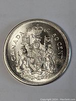 Front side of the 1962 Canadian 50 cent silver coin showing the Canadian coat of arms with crown, lion, and unicorn supporting a shield with a banner. The year and denomination are stamped at the top and right side respectively.