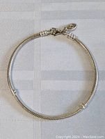 Full view of the 8-inch sterling silver snake chain bracelet or anklet laid flat on fabric.