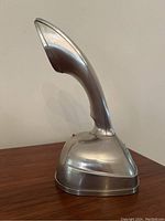 Side view of the vintage Mercer Cobra telephone showing the curved handset and stainless steel finish