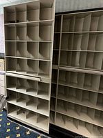 Photo of multiple steel filing shelves with compartments and vertical dividers, used for medical records storage.