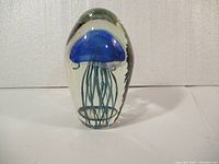 Front view of the jellyfish art glass paperweight showing detailed blue jellyfish inside transparent glass.