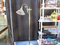 Full view of the 63 inch tall brass floor lamp standing upright with frosted glass shade.