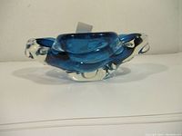 Front side view of signed Chalet glass bowl showing thick clear and blue glass with rounded, flowing shape.