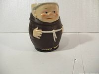 Front view of the ceramic monk jug with detailed face and robe.