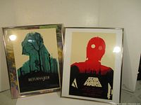 Two framed Star Wars posters displayed side by side, one Return of the Jedi with green silhouette, one Star Wars in red and black featuring C-3PO