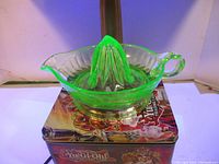 Uranium glass reamer under UV light showing bright green fluorescence on a Yu-Gi-Oh! themed surface.