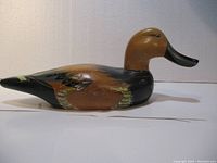Side view of the wooden duck decoy showing painted details and overall shape