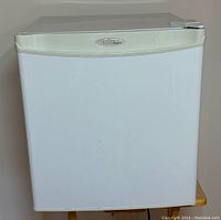 Front view of a white Denby mini fridge showing cream trim and logo on door.