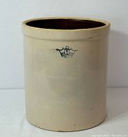 Front exterior view showing beige cylindrical form and crown emblem