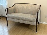 Front-left angle showing overall shape, upholstery, and wood frame