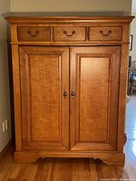 Straight-on front view showing full armoire with drawers and doors