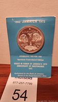 Front of blue cardstock holder showing the coin in clear circular window, text including '1962 Jamaica 1972', 'Sterling Silver $10', 'Specimen Uncirculated Edition', and details about the coin honoring Jamaica's 10th anniversary of independence.