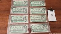 Eight 1967 Canadian one dollar bills, front side showing Queen Elizabeth II and denomination.