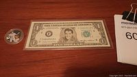 Photo showing novelty $1 banknote with Elvis Presley portrait in central oval, serial numbers visible.