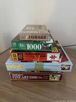 Stacked view of various puzzles and board game showing box titles and piece counts