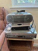 Photo of the stacked electronic devices: Sony CFD-S01 CD radio cassette recorder on top, Topfield set-top box below, and Arris HDPVR 630 at the bottom.