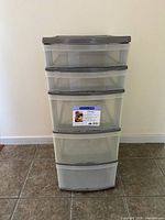 Front view of five-drawer plastic storage tote with a label on the third drawer showing brand and product info.