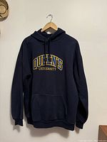 Full front view of navy blue hoodie sweater with Queen's University embroidery showing design and overall condition.