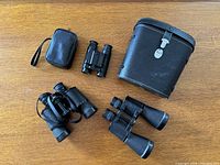 Top view showing all binoculars and carrying case on wood surface