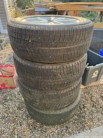 Stack of four tires showing tread patterns and overall condition
