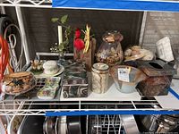 Full set of assorted decorative containers, glass potpourri vessels, ceramic and stone lidded containers arranged on wire rack