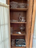 Overview of the 11 pieces on wooden shelves including bowls, pitcher, vase, candy dish, plates, and trays.