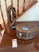 Photo showing both the sculptural hands and the mirrored decorative box on a wooden surface