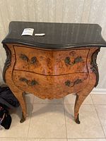 Full view of the wooden side table with two drawers and a black marble top. Shows overall design, handles, legs, and condition of wood.