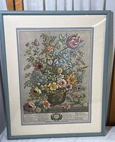 Full view of framed lithograph showing floral arrangement and botanical labels below.