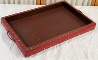 Full view of the rectangular tray showing red leather or vinyl wrap with brass nailhead trim and integrated handles.