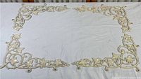 Four wrought iron corner pieces laid out to show size and design, cream painted finish with leaf and vine motifs.