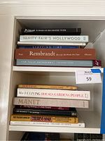 Books stacked horizontally on shelves and next to each other, titles clearly visible.