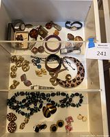 Multi-shelf drawer overview with assorted watches, jewelry boxes, bracelets, necklaces and earrings.