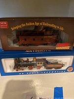 HO scale locomotive with tender in styrofoam tray under glass, Roundhouse caboose in original box with front clear window