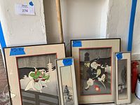 Four framed Japanese art prints arranged against wall, two larger prints with figures and two smaller with nature scenes