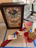 Photo showing the planting season clock, vintage fireplace bellow, and three decorative scent bottles with unique carved headpieces.