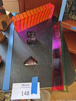 Overview of four acrylic sculptures on black surface