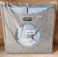 Front view of the JESPET cat condo cube wrapped in plastic showing the circular entrance and attached label.