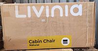 Box labeled Livinia Cabin Chair Natural, likely packaging for the chairs or related furniture.