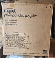 Photo of the product packaging box showing the brand MYPET North States Paws Portable Petgate, dimensions 26-40 inches wide, 23 inches tall, with an illustration of the gate design and American flag indicating made in USA.