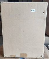 Closed cardboard box containing the wall sconce, showing distressed packaging with label M042.